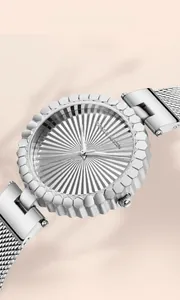 Detailed close-up of a silver sunray dial watch with geometric textured bezel and mesh strap