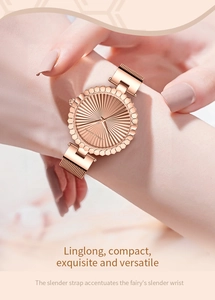 Close-up of a compact rose gold women's watch with a woven metal strap and sunray dial