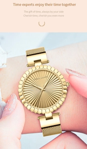 Detailed close-up of golden Hannah Martin watch with sunray dial and mesh strap