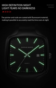 Detail of square watch face with luminous hands and date window showing night visibility