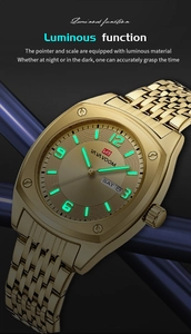 Macro shot of luminous hands and double calendar window on golden stainless steel watch