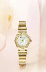 Détail d'une montre dorée pour femme avec lunette diamantée et cadran en nacre