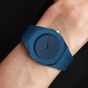 Close-up of minimalist blue octagonal quartz watch with silicone strap on wrist