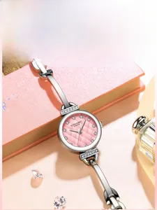 Gros plan détaillé du cadran rose serti de diamants et du bracelet argenté de la montre