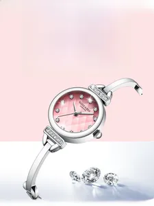 Détails du cadran rose diamanté et du bracelet jonc argenté d'une montre quartz femme