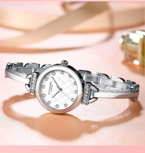 Détail d'une montre argentée pour femme avec cadran strass sur soie rose élégante