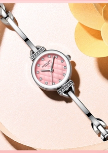 Détail du cadran rose serti de diamants avec bracelet argenté et strass sur la montre