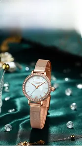 Détail de la montre en or rose avec cadran nacré et lunette en cristal sur velours