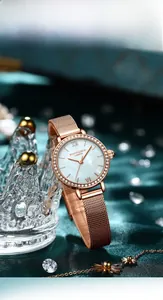 Gros plan sur une montre en maille or rose avec lunette sertie de cristaux brillants