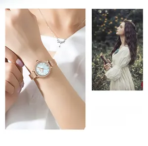 Détail d'une montre à quartz or rose avec cadran nacré bleu et bracelet maille