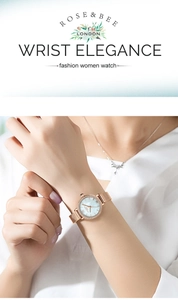 Gros plan d'une montre à quartz pour femme avec bracelet maille rose doré et lunette en strass