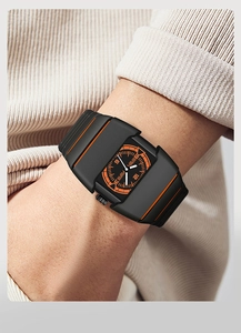 Gros plan d'un boîtier de montre futuriste noir et orange avec bracelet en silicone robuste