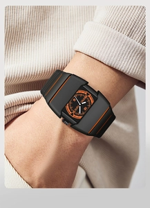 Détail d'une montre de sport noire futuriste avec rayures oranges et cadran lumineux