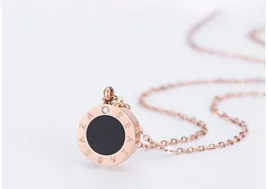 Vue macro d'un collier double anneau or rose avec disque noir et pendentif en cristal