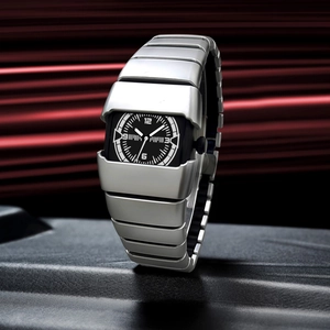 Montre futuriste en acier argenté avec cadran carré noir sur socle sombre