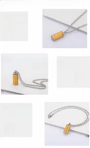 Detailed macro view of the gold stainless steel cylinder pendant with engraved scriptures