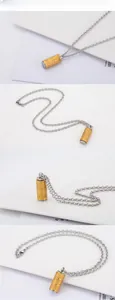 Detailed close-up of rotating golden sutra cylinder pendant with silver metal chain