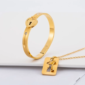 Vergulde hartslot armband en sleutel ketting set met sprankelende kristallen accenten