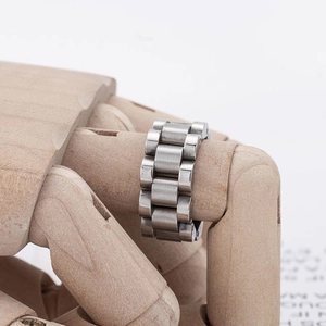 Brushed stainless steel watch band style ring for men and women on a wooden model hand