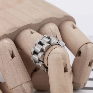 Industrial stainless steel watch band style ring with matte brushed finish on wooden hand