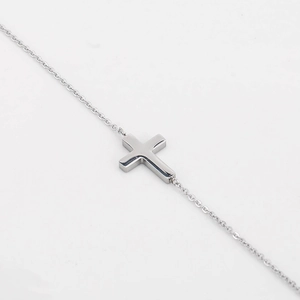 Minimalist adjustable stainless steel cross bracelet with a polished silver finish
