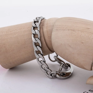 Bracelet gourmette poli en acier inoxydable argenté sur un bras de mannequin en bois