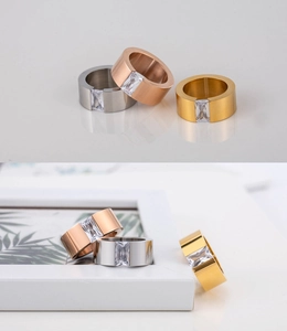 Detalle de anillos anchos bañados en oro 18K con circonitas de talla rectangular