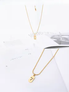 Detailed close-up of gold snake chain necklace with hollow number 7 rectangle pendant