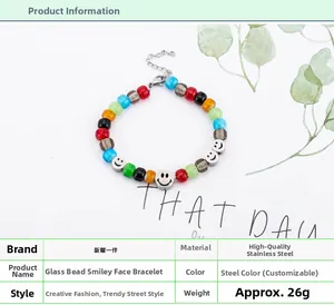 Dettaglio di perline di vetro colorate e ciondoli a forma di smiley su un bracciale in acciaio