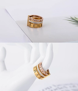 Dettaglio anello in oro rosa con numeri romani, tripla fascia e cristalli incastonati