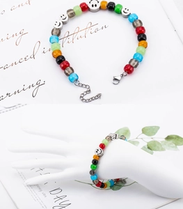 Dettaglio del bracciale di perline colorate con ciondoli smiley argento e catenella