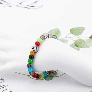 Bracciale di perline di vetro colorate con ciondoli smiley su un modello di mano