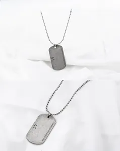 Detail of vintage silver military dog tag necklace with engraved distinction slogan