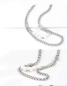 Détail du collier argenté à double épaisseur avec perles blanches et maillons de chaîne