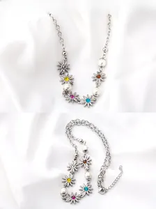 Dettaglio della collana in acciaio al titanio con fiori di cristallo colorati e perle bianche