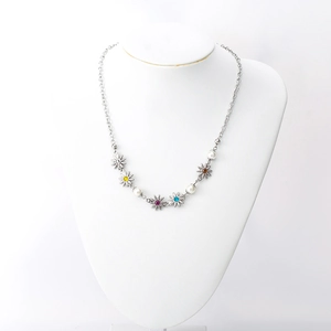 Collana in acciaio al titanio con ciondoli margherita colorati e perle bianche su busto
