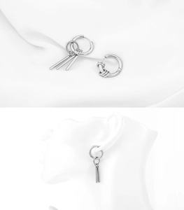 Detailed macro view of asymmetric silver titanium steel earrings with cylindrical charms