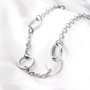 Minimalist silver stainless steel O-chain necklace with interlaced geometric rings on silk