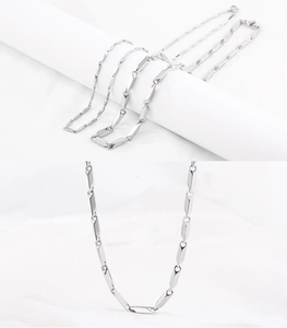 Detailed close-up of polished stainless steel necklace with geometric faceted link design