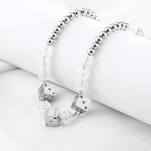 Collier punk en acier titane avec perles réfléchissantes et pendentifs dés sur support blanc