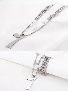 Détail du collier punk argenté avec pendentif numéro 7 et textures multi-chaînes
