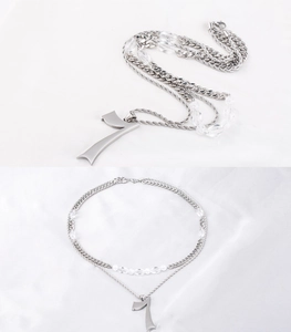 Détail du collier double rang en acier titane avec chiffre 7 porte-bonheur et chaîne cubaine