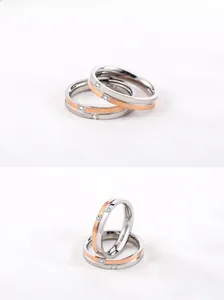 Detail of titanium steel couple rings with rose gold plating and inlaid crystals
