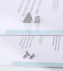 Detailed view of matte silver irregular geometric earrings with butterfly backings