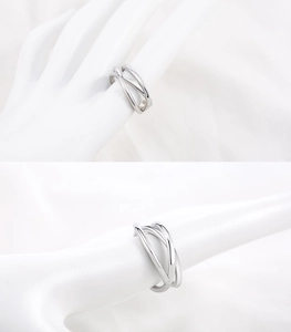 Detail of silver irregular cross geometric titanium steel ring on a finger model