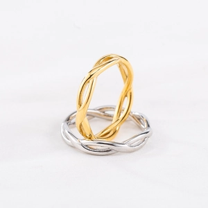 Minimalist twisted rope rings in gold and silver finish on a clean white background