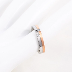 Polished titanium steel ring with rose gold plating and small diamonds on hand model
