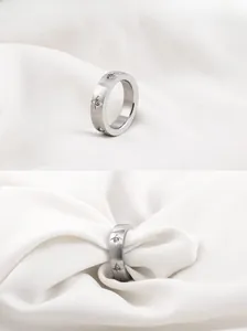 Detail of matte brushed titanium steel ring with sparkling star-set diamonds