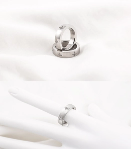 Detail of brushed titanium steel rings with star patterns and inlaid zircons