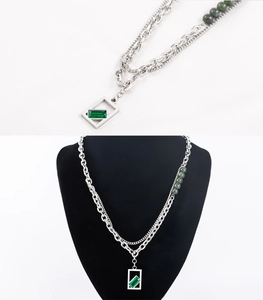 Detail of double-layer titanium steel necklace with square emerald pendant and green beads